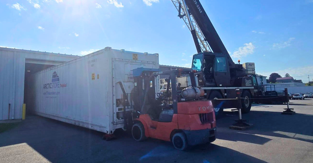 Mobile crane lifting a shipping container into a tight-access yard in Lancaster County, PA